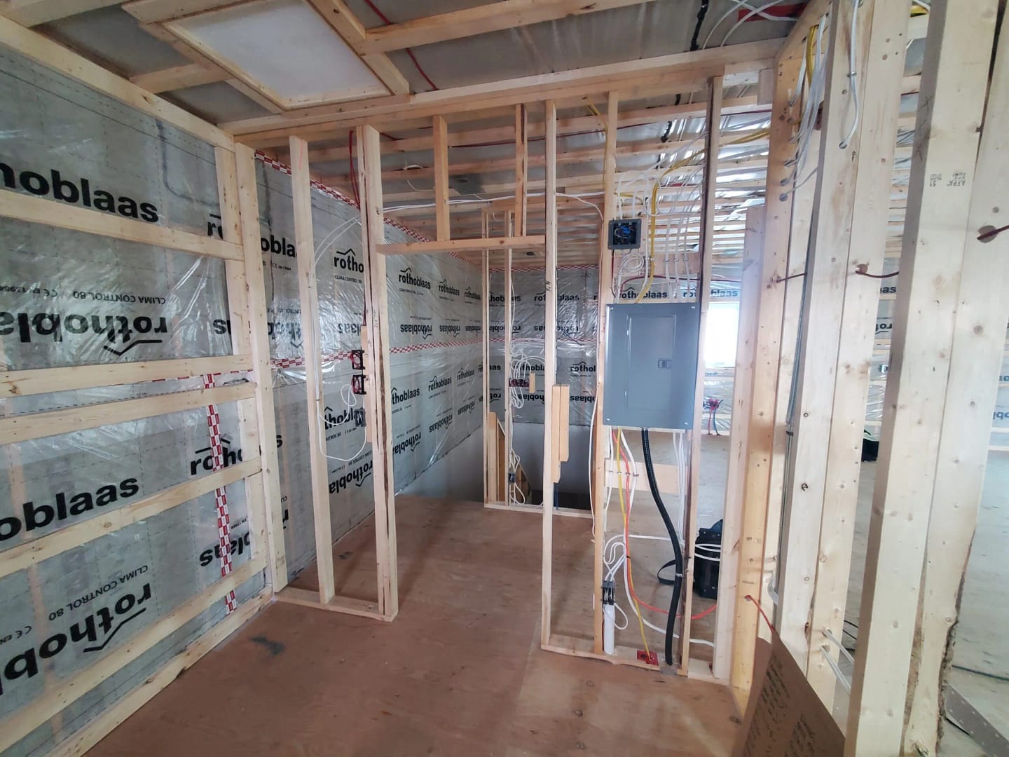 Residential Electrical installation in Yellowknife Wood stud wall prior to being covered by drywall; containing electrical wiring, outlets and electrical panel